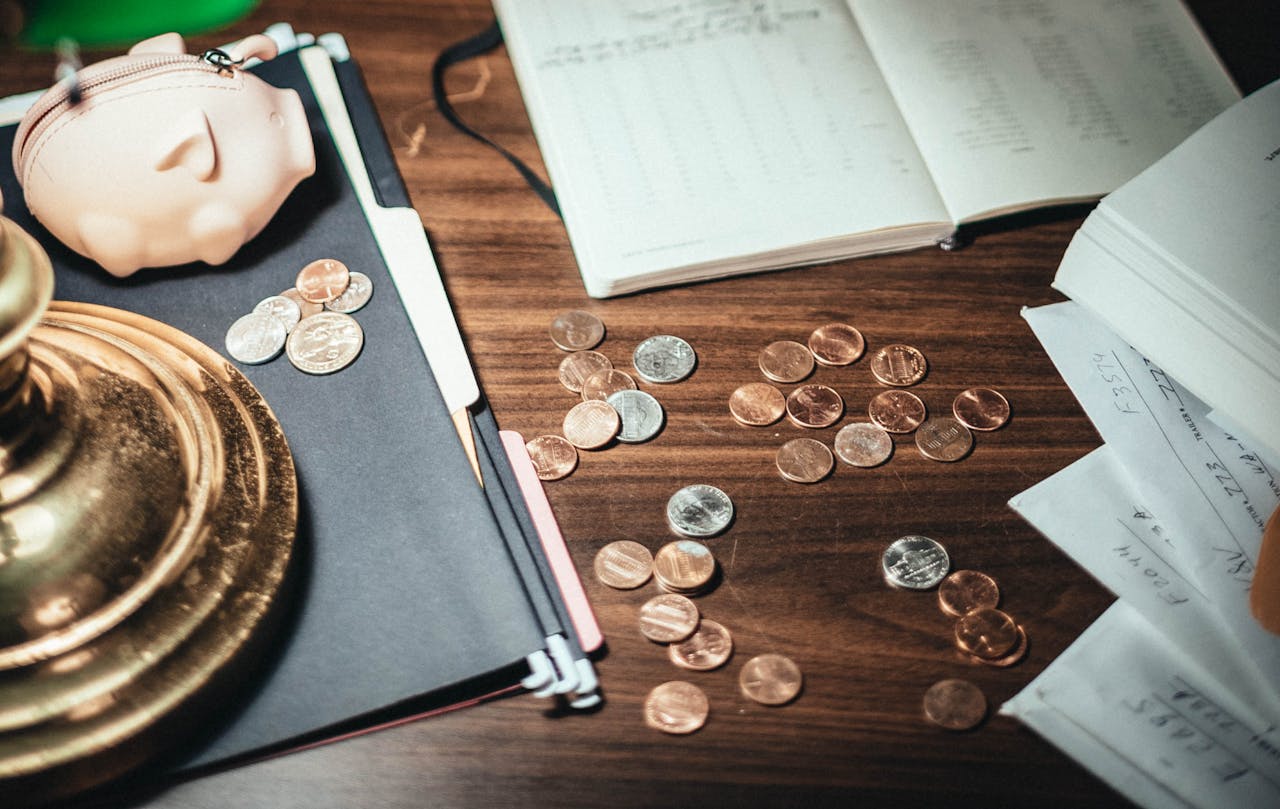 hero-img From above coins scattered on desk near financial papers and lovely pig wallet in accountant office